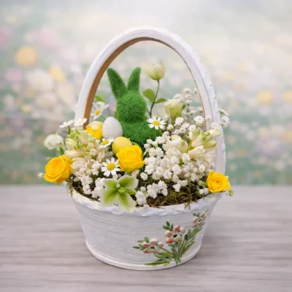 Aranjament de Paște în coș alb ceramic cu iepuraș verde, flori albe și galbene și ouă decorative pastel